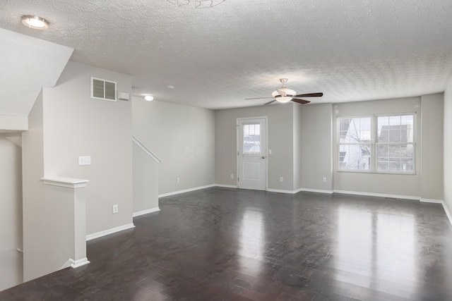 interior space featuring ceiling fan, a textured ceiling, and dark hardwood / wood-style flooring