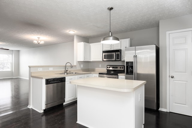 kitchen with white cabinetry, appliances with stainless steel finishes, sink, and decorative light fixtures