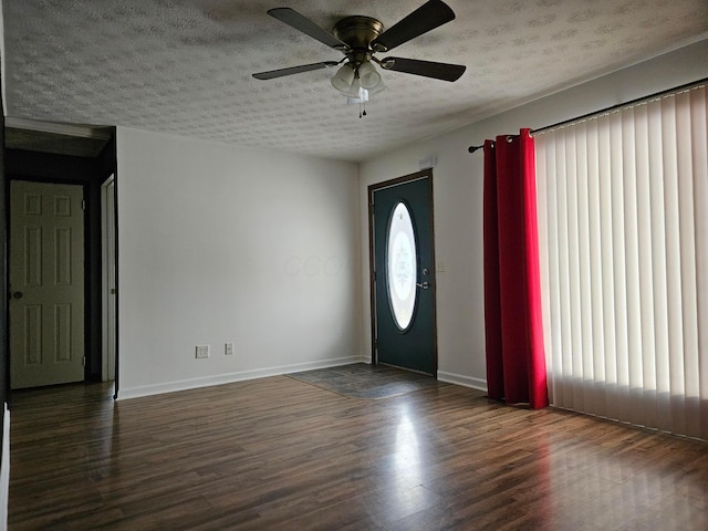 foyer featuring ceiling fan, dark hardwood / wood-style flooring, and a textured ceiling