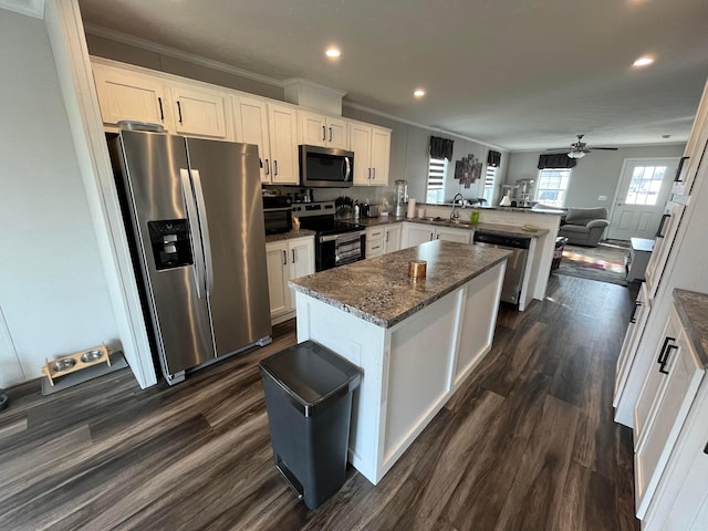 kitchen featuring a kitchen island, kitchen peninsula, white cabinets, and appliances with stainless steel finishes