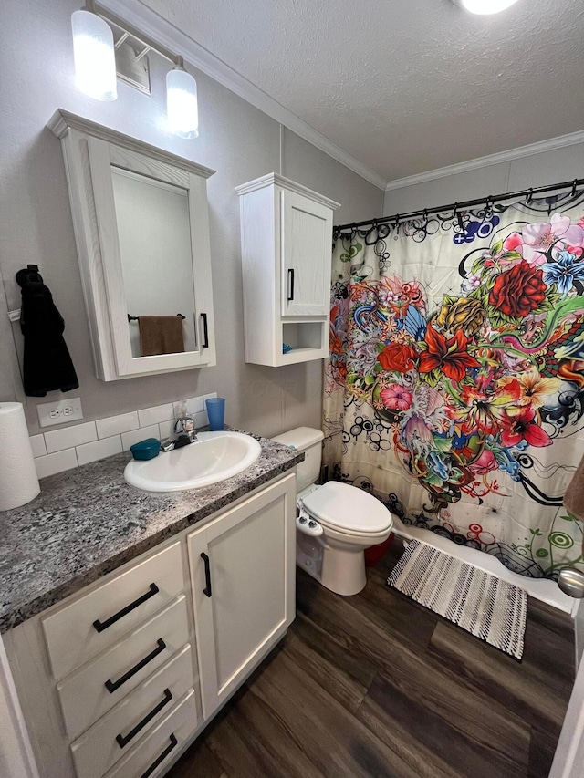 bathroom with toilet, wood-type flooring, a textured ceiling, ornamental molding, and vanity