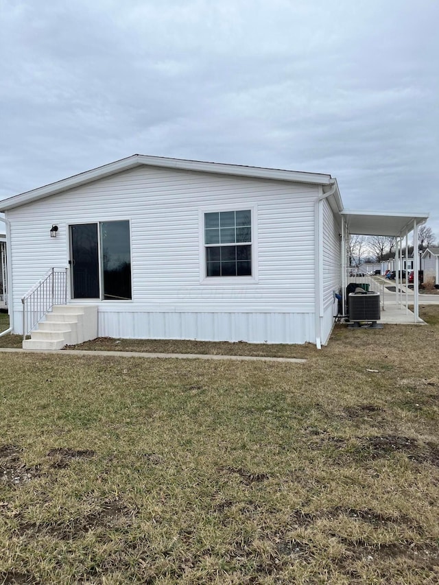 view of home's exterior with a carport, central AC unit, and a lawn