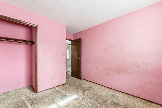 unfurnished bedroom featuring light colored carpet and a textured ceiling