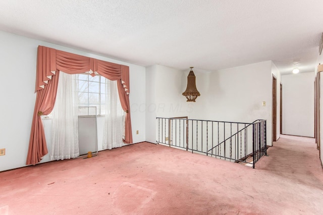 carpeted spare room featuring a textured ceiling