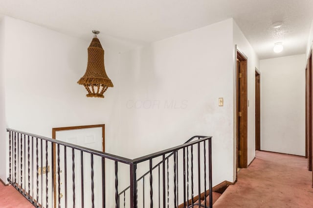 corridor with carpet and a textured ceiling