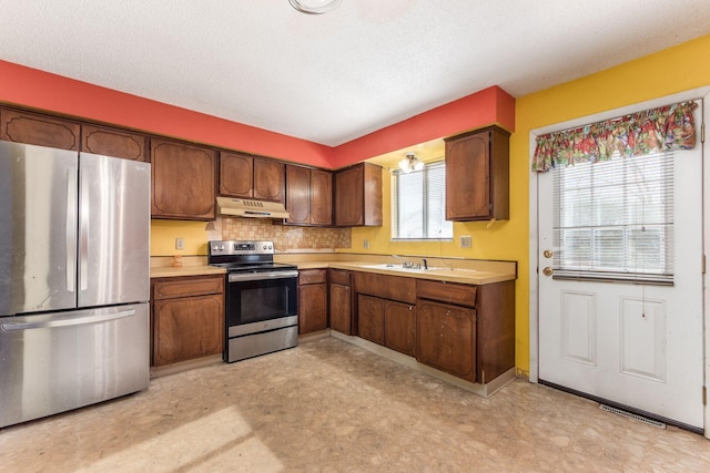 kitchen featuring stainless steel appliances, dark brown cabinets, sink, and a textured ceiling