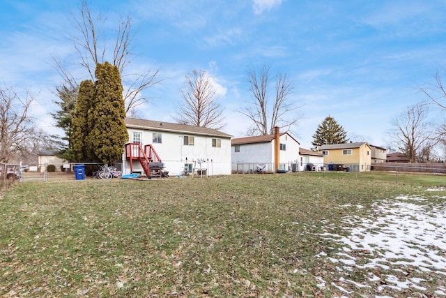 rear view of property featuring a lawn