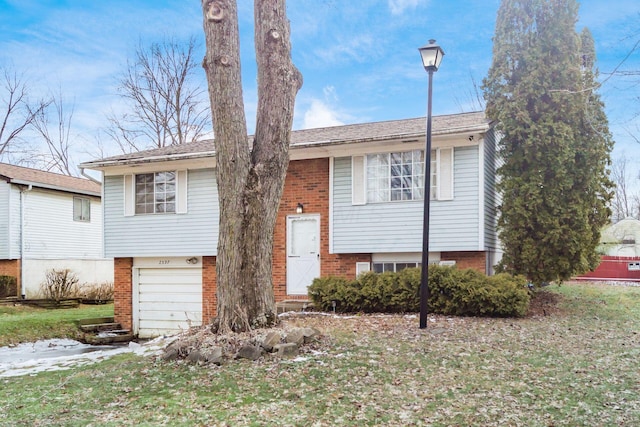 split foyer home featuring a garage and a front yard