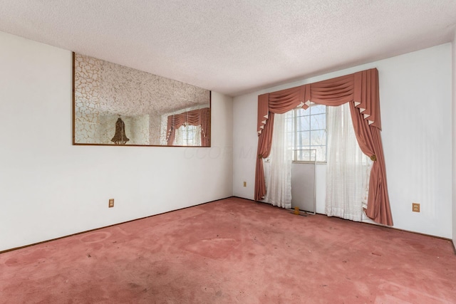 unfurnished room featuring carpet flooring and a textured ceiling