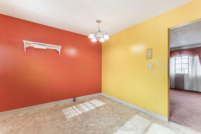 empty room with an inviting chandelier and a textured ceiling