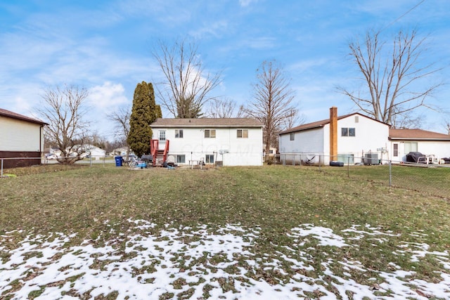 snow covered property featuring central AC unit and a yard