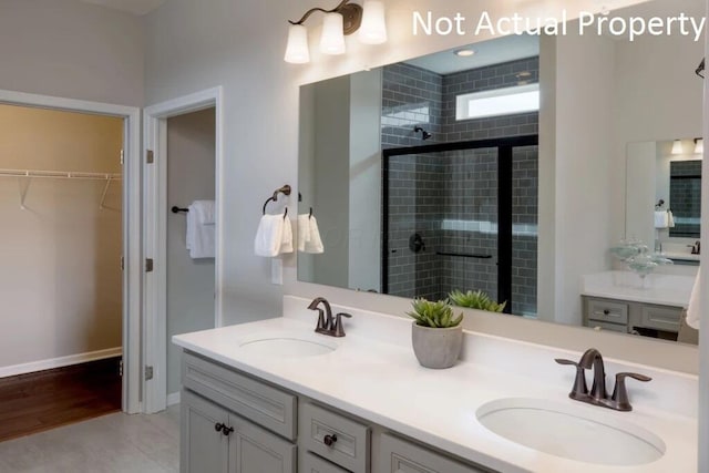 bathroom with a shower with door and vanity