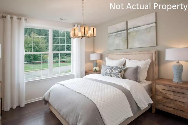 bedroom with dark hardwood / wood-style flooring and a notable chandelier