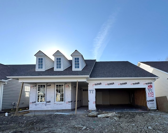 view of front of home featuring an attached garage and a shingled roof