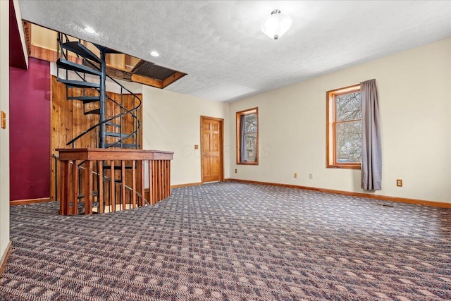 carpeted empty room featuring a textured ceiling