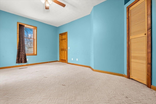 interior space with ceiling fan, a closet, light carpet, and a textured ceiling