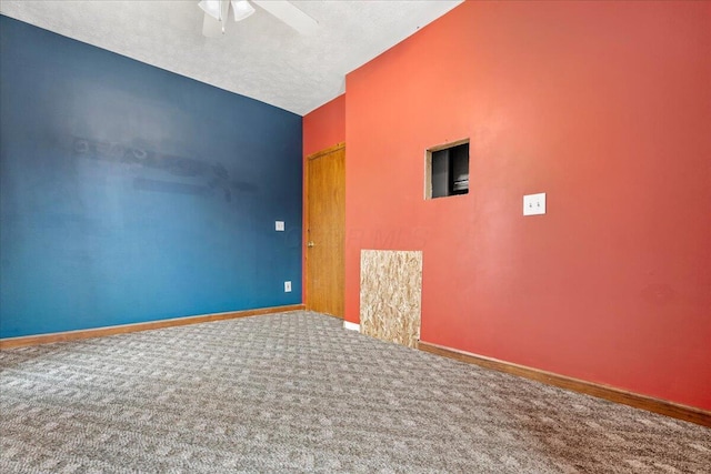 empty room featuring ceiling fan, vaulted ceiling, carpet, and a textured ceiling