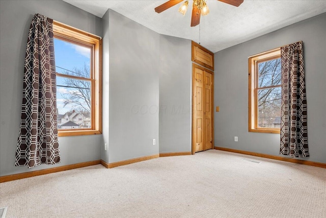 unfurnished bedroom with ceiling fan, a textured ceiling, and carpet flooring