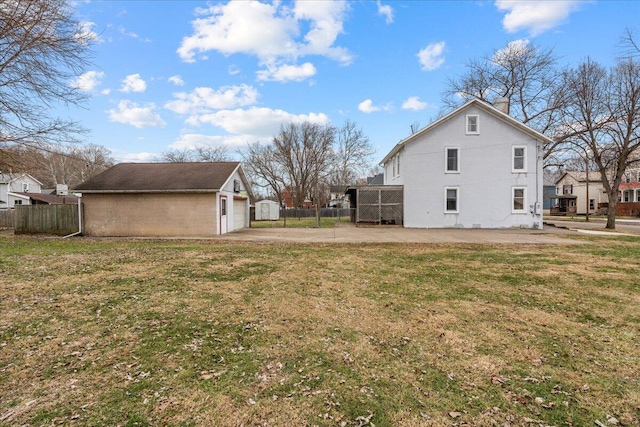 exterior space featuring a garage, a yard, and an outbuilding