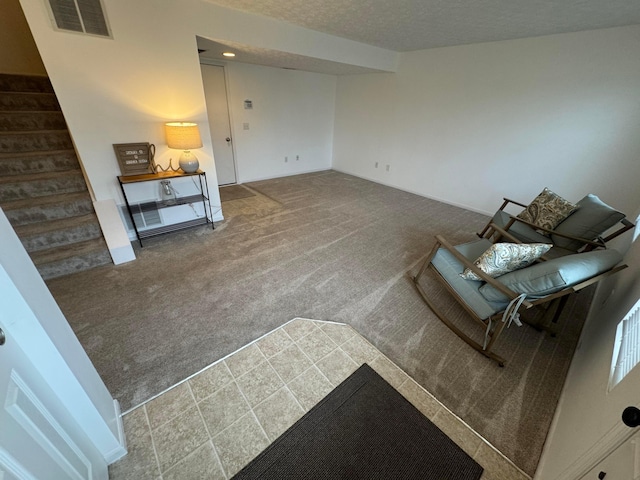 carpeted living room featuring a textured ceiling