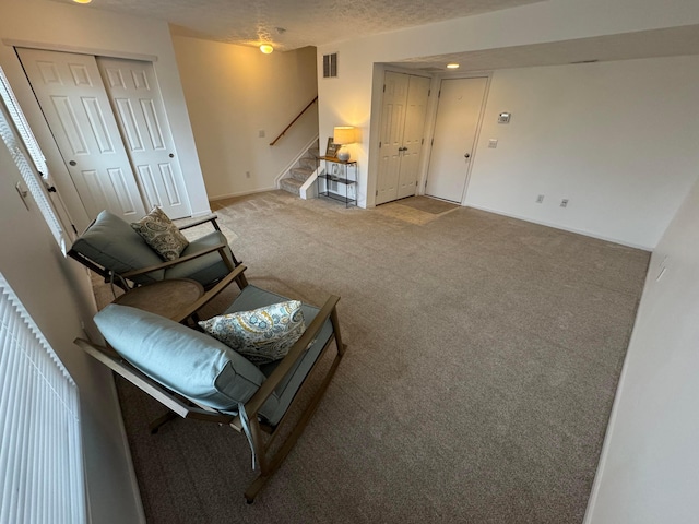 carpeted living room featuring a textured ceiling