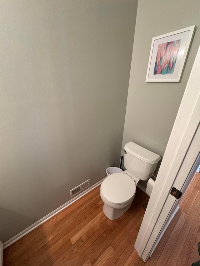 bathroom featuring hardwood / wood-style flooring and toilet