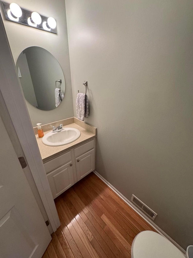 bathroom featuring hardwood / wood-style flooring, vanity, and toilet