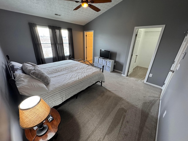 carpeted bedroom featuring vaulted ceiling, ceiling fan, and a textured ceiling