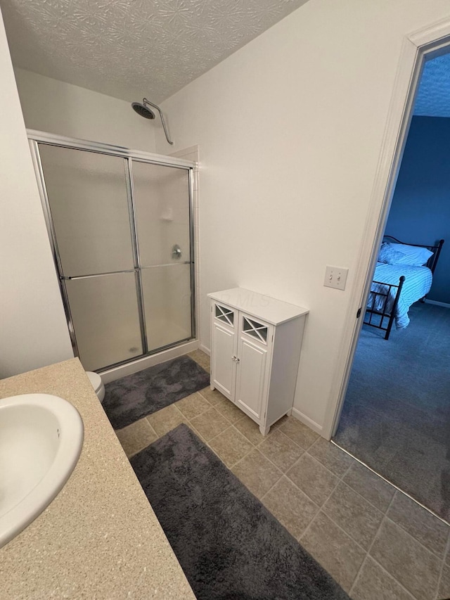 bathroom featuring walk in shower, vanity, toilet, and a textured ceiling