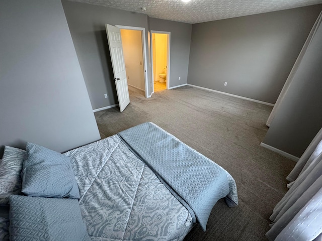 bedroom featuring carpet, a textured ceiling, and ensuite bath