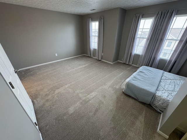 bedroom featuring a textured ceiling and carpet