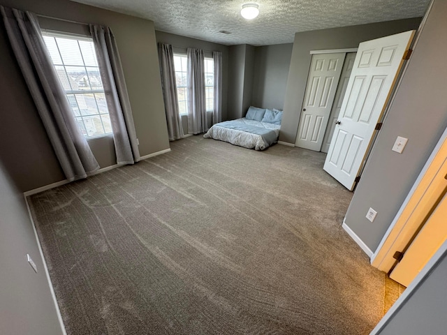 unfurnished bedroom featuring a closet, a textured ceiling, and carpet