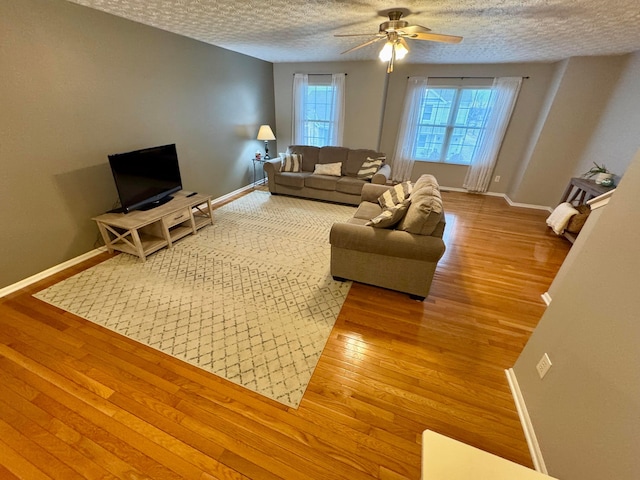 living room featuring hardwood / wood-style floors, a textured ceiling, and ceiling fan