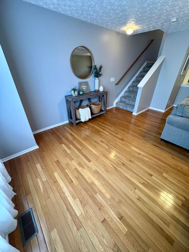 entryway with a textured ceiling and light wood-type flooring