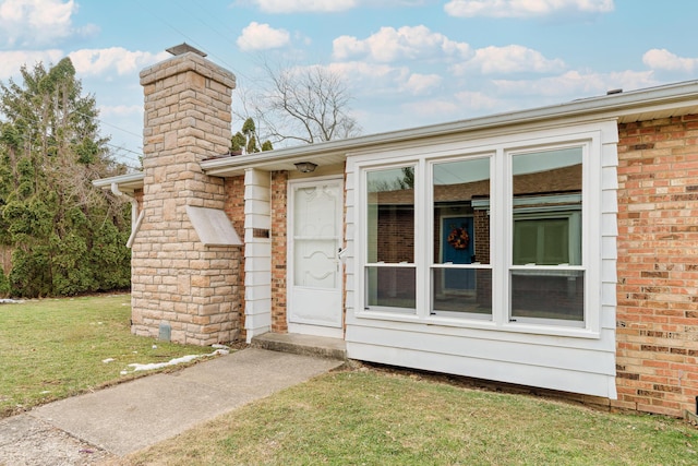 view of exterior entry with a lawn