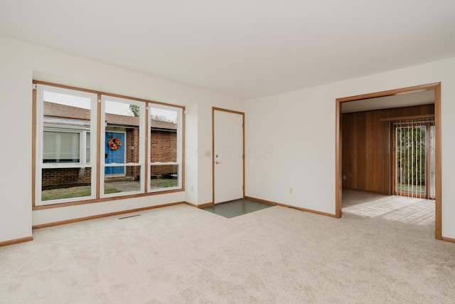 carpeted empty room with wooden walls