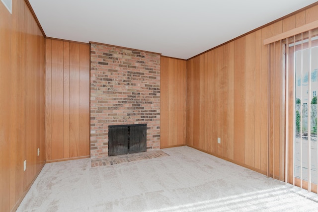 unfurnished living room featuring crown molding, a fireplace, light carpet, and wood walls