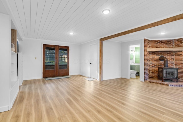 unfurnished living room with french doors, wood ceiling, crown molding, light wood-type flooring, and a wood stove