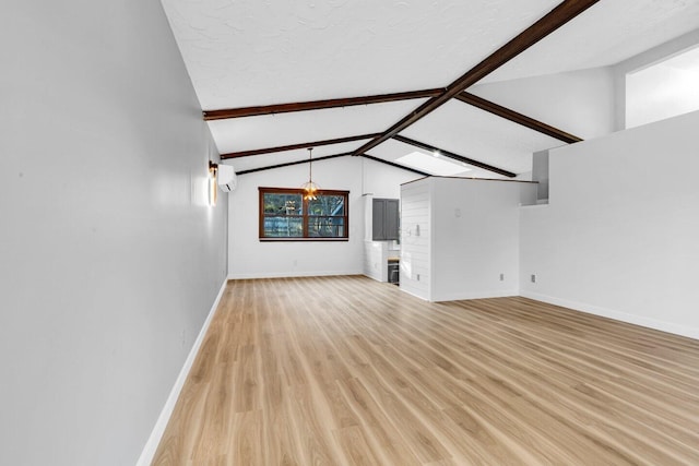 unfurnished living room with an AC wall unit, vaulted ceiling with beams, a textured ceiling, and light hardwood / wood-style flooring