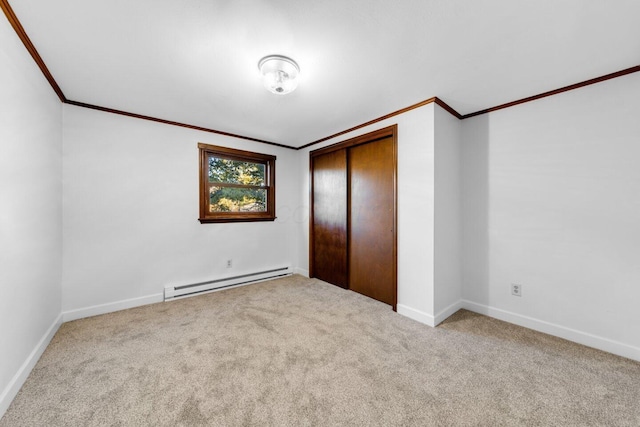 unfurnished bedroom featuring ornamental molding, a baseboard heating unit, light colored carpet, and a closet