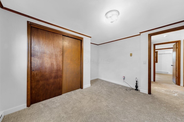 unfurnished bedroom featuring crown molding, light carpet, baseboard heating, and a closet