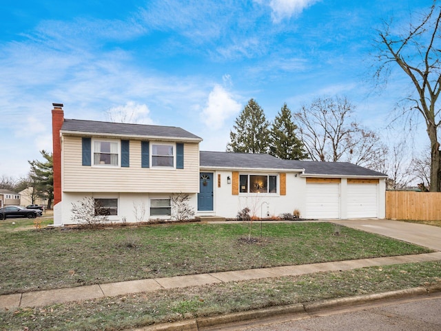 tri-level home with a garage and a front lawn