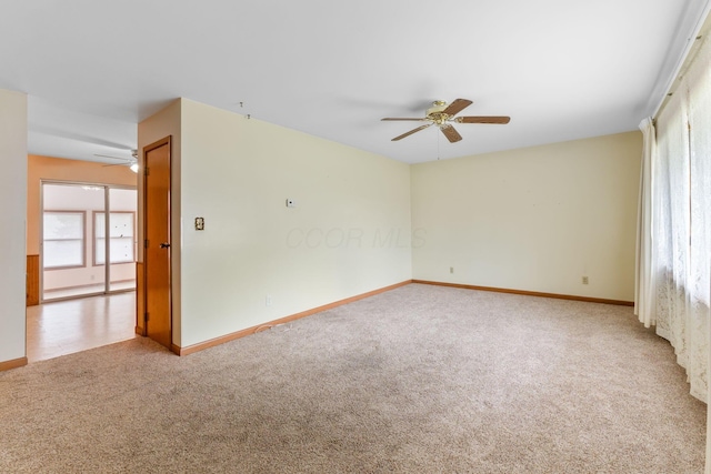 carpeted spare room featuring ceiling fan