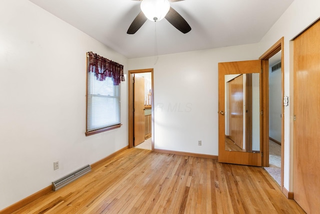 unfurnished bedroom with ceiling fan, a baseboard radiator, light hardwood / wood-style floors, and a closet