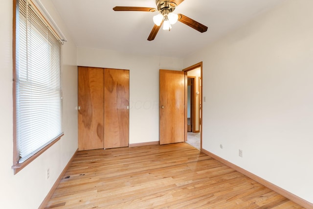 unfurnished bedroom featuring ceiling fan, light hardwood / wood-style floors, and a closet