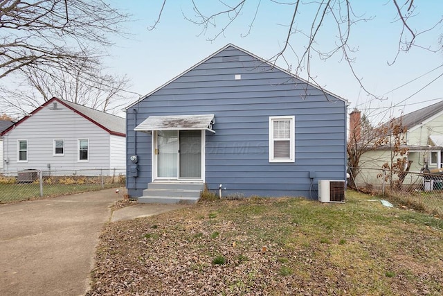 bungalow-style house with a front lawn and central air condition unit