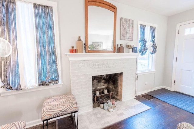 living area with hardwood / wood-style floors and a brick fireplace