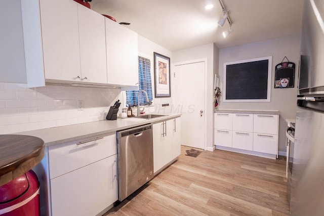 kitchen featuring white cabinetry, light hardwood / wood-style floors, dishwasher, and sink