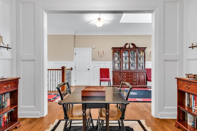 dining space featuring crown molding and light wood-type flooring