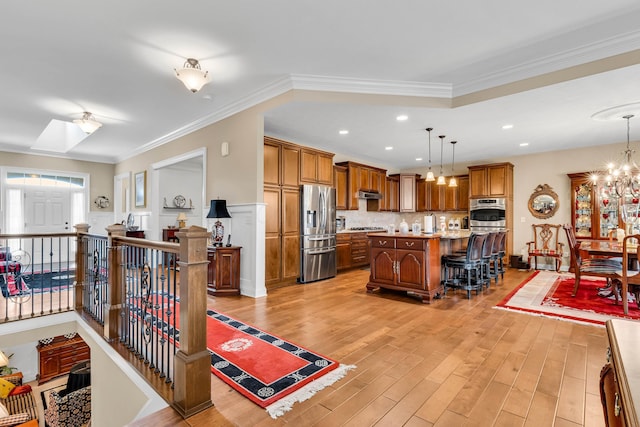 kitchen featuring a breakfast bar area, hanging light fixtures, a kitchen island, stainless steel fridge with ice dispenser, and a chandelier